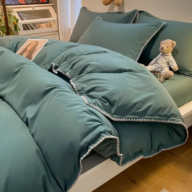 Teal-colored quilted comforter with white zigzag stitching features cozy shell edges in a decorbites cozy shell bedding set