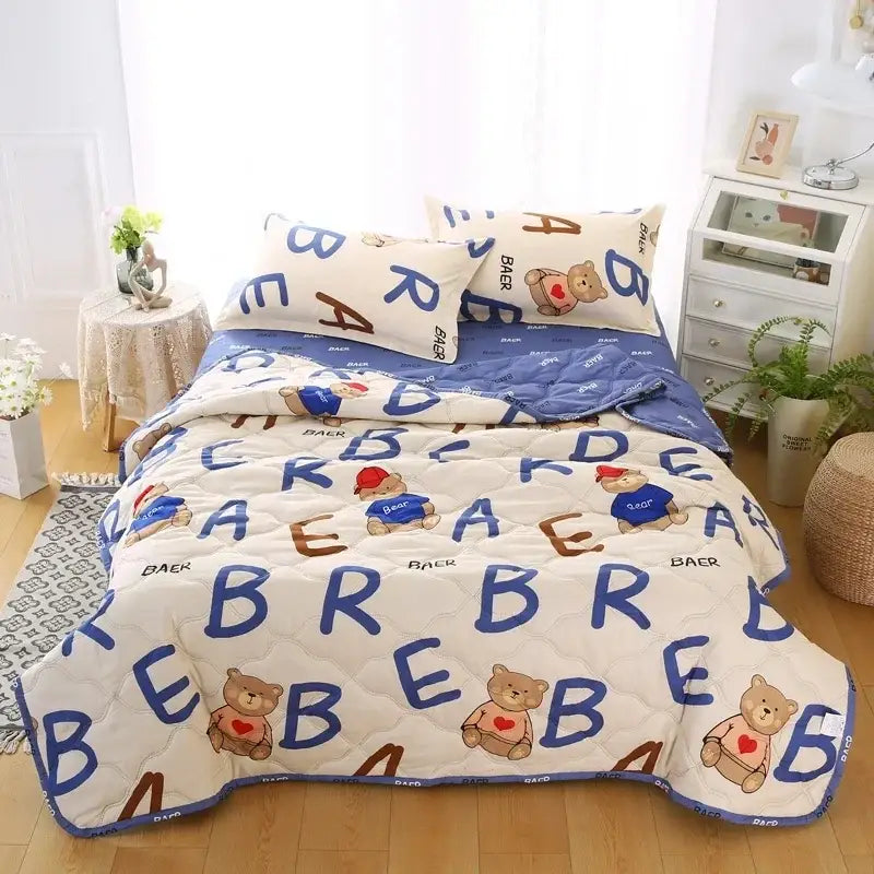 Cream bear quilt and pillowcase set featuring cream color, blue and brown lettering, cartoon bears, and stitched pattern for a restful night’s sleep