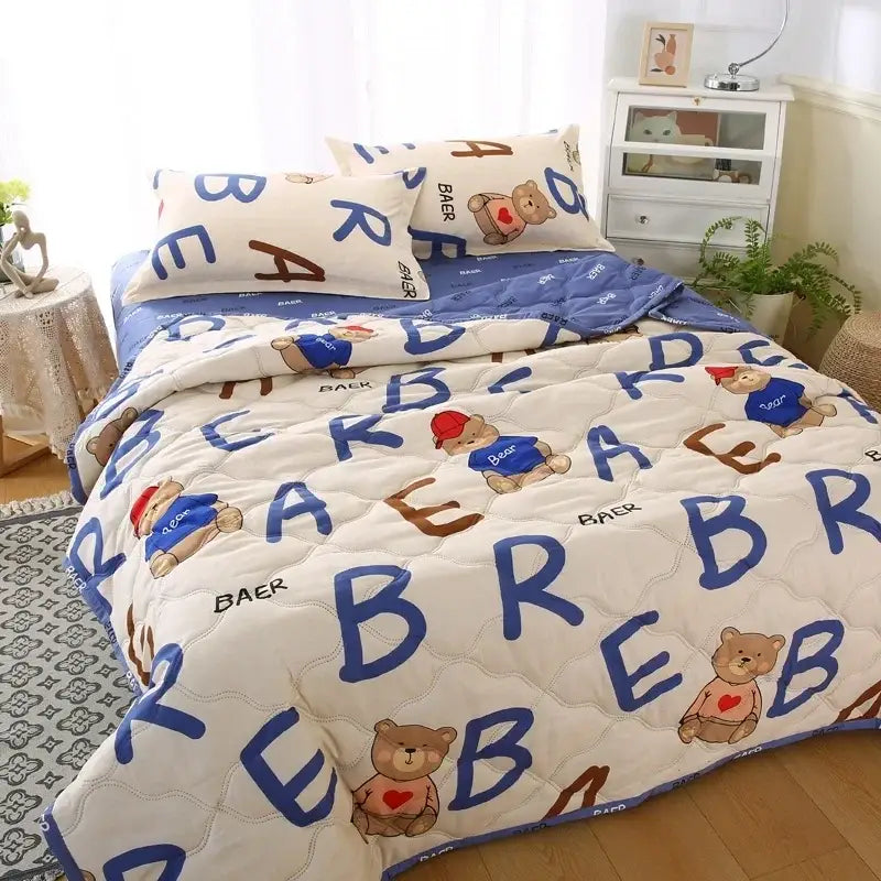 Cream bear quilt and pillowcase set featuring playful bears in blue and brown outfits on a cream bedding set