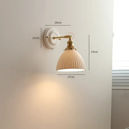 Cream ceramic led wall light with copper arm featuring ribbed ceramic lampshade and brass-finished mounting plate decorbites ceramic led