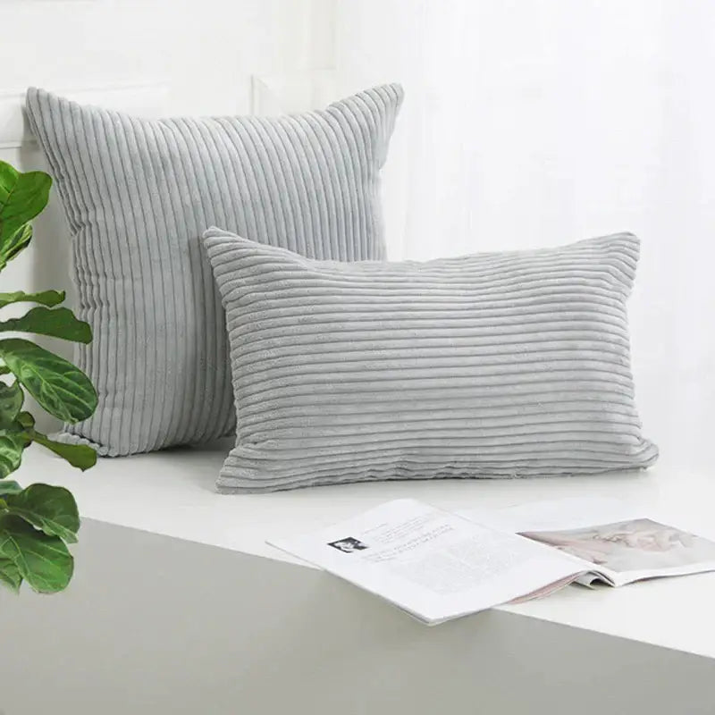 Two light gray decorbites corduroy striped cushion covers with vertical ribbed texture in square and rectangular shapes