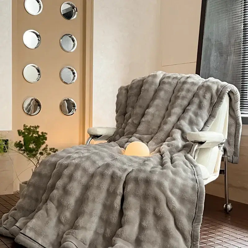 A plush gray throw blanket with soft fuzzy surface and subtle ribbed pattern from decorbites cozy bubble faux rabbit fur collection