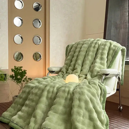Cream cozy bubble faux rabbit fur bedroom throw in light green with textured quilted pattern draped on modern chair