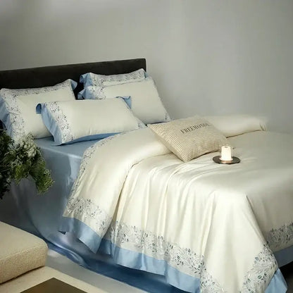 Cream embroidered egyptian cotton bedding set with satin duvet cover featuring light blue trim and silver floral embroidery