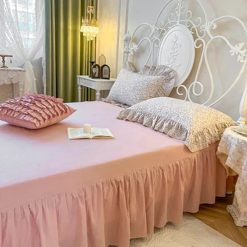 Pink ruffled bed skirt with soft flowing fabric and lace ruffles complements cream floral double layer lace bedding set