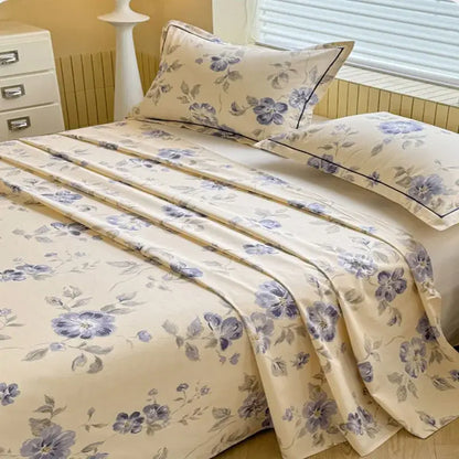 Cream flower print satin bed cover featuring cream color, delicate purple gray floral patterns, and black piping accents