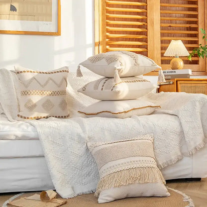 Beige cream geometric tufted cushion cover with macrame fringe and tassels stacked on white couch for decorbites decor