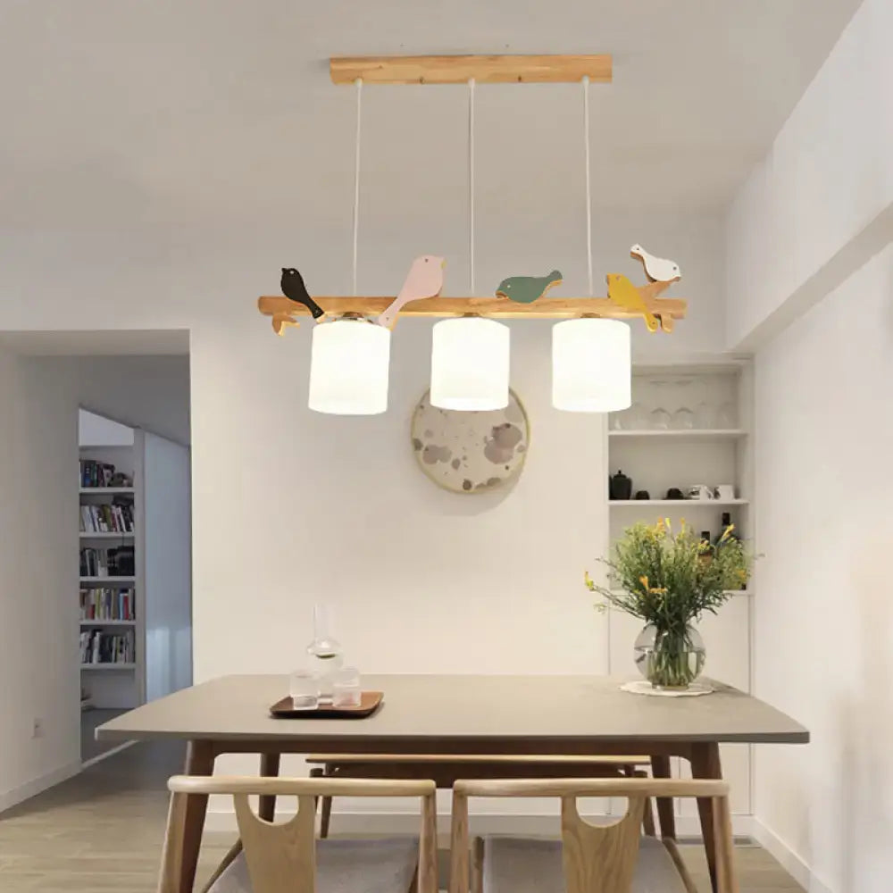 Wooden bird-themed pendant light with three cream glass cylindrical shades for dining room island chandelier lighting