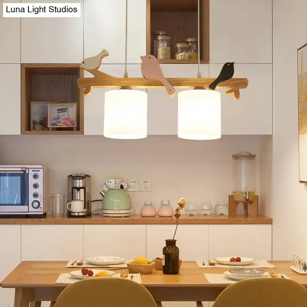 Wooden pendant light with cream glass cylindrical shades and wooden bird cutouts for dining room island chandelier