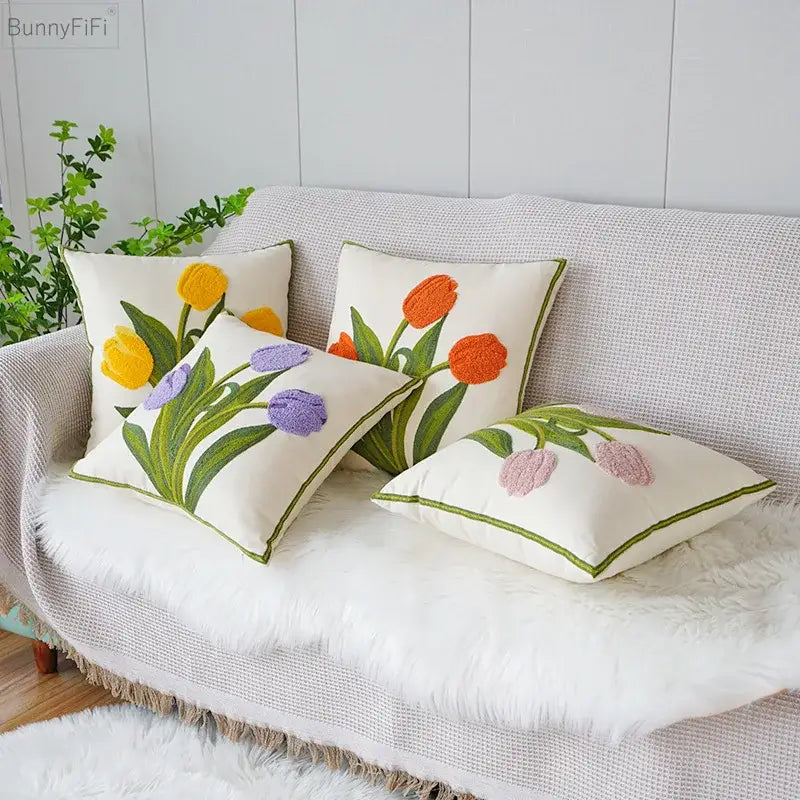 Set of four cream fabric throw pillows with decorbites green tulip embroidery and green piping for living room decor