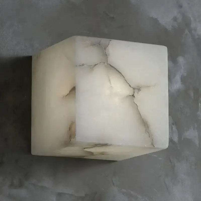 Cream onyx cube marble wall lamp with natural veining and prominent crack for elegant bedroom decorbites cube marble sconce