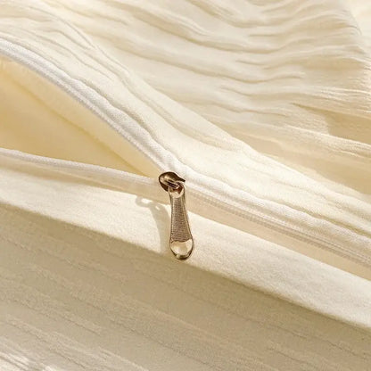 A gold-toned zipper pull on cream ribbed bubble yarn fabric of decorbites bubble yarn bedding set duvet cover