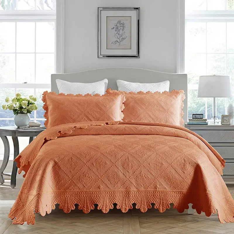 Coral-colored quilt set with scalloped edges and diamond pattern featuring cotton embroidery quilt texture