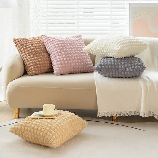 A set of four elastic puff plaid cushion covers in beige pink white and gray with a plush quilted surface for living room decor