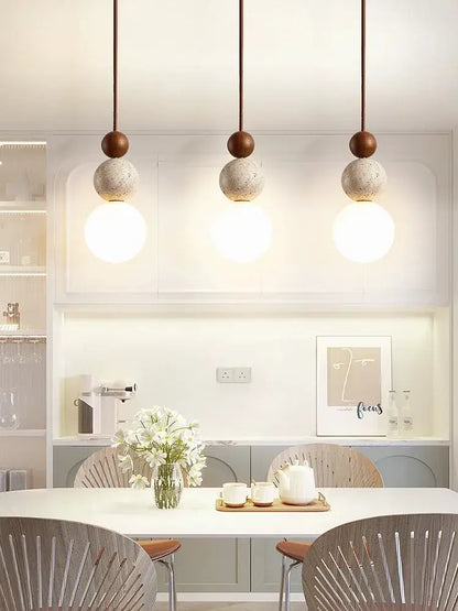 Three modern cream style led pendant lamps with matte brown tops and textured concrete spheres for bedroom decorbites decor