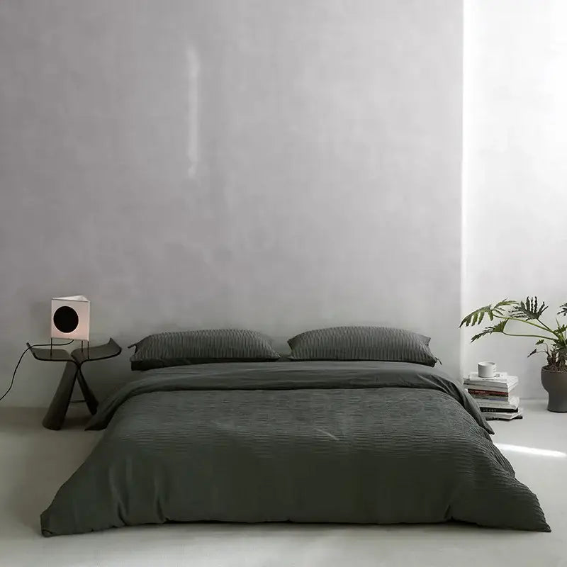 Dark gray ribbed duvet cover set with matching pillows on a minimalist bed featuring cotton foam yarn bedding set
