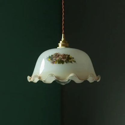 Cream vintage brass pendant light featuring a cream-colored glass shade with floral design and scalloped edge for dining room decor