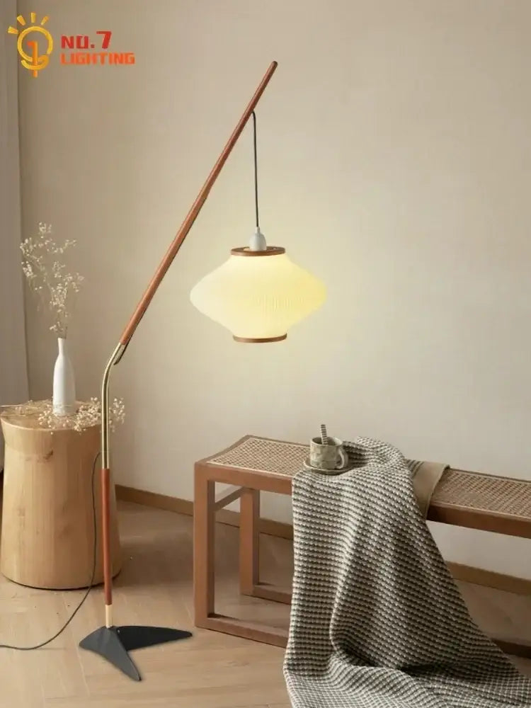 A floor lamp with a curved wooden arm brass accents and oval frosted glass shade for living room decorbites cream wind