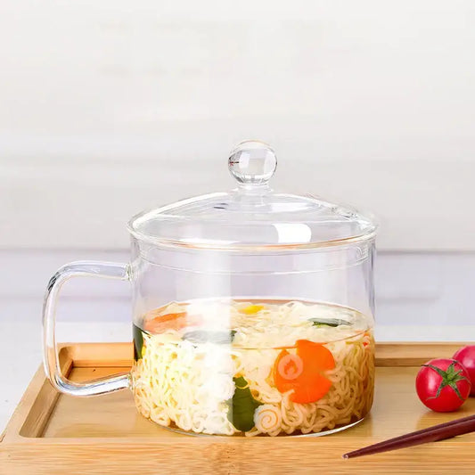 Creative clear glass salad bowl with handle filled with noodles and vegetables in broth for kitchen and dining room use