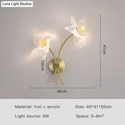 Brass-toned floral decorative gold led wall lamp with two white acrylic flowers and golden-yellow crystal centers for bedroom