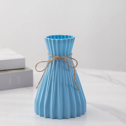 A light blue pleated plastic flower bottle type vase with twine bow in modern dry flower bottle design