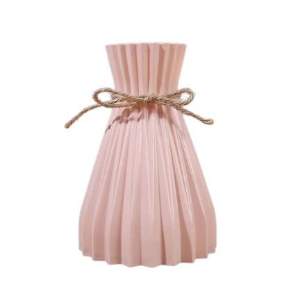 A blush pink pleated ceramic flower bottle adorned with a rustic twine bow perfect as a dry flower bottle type