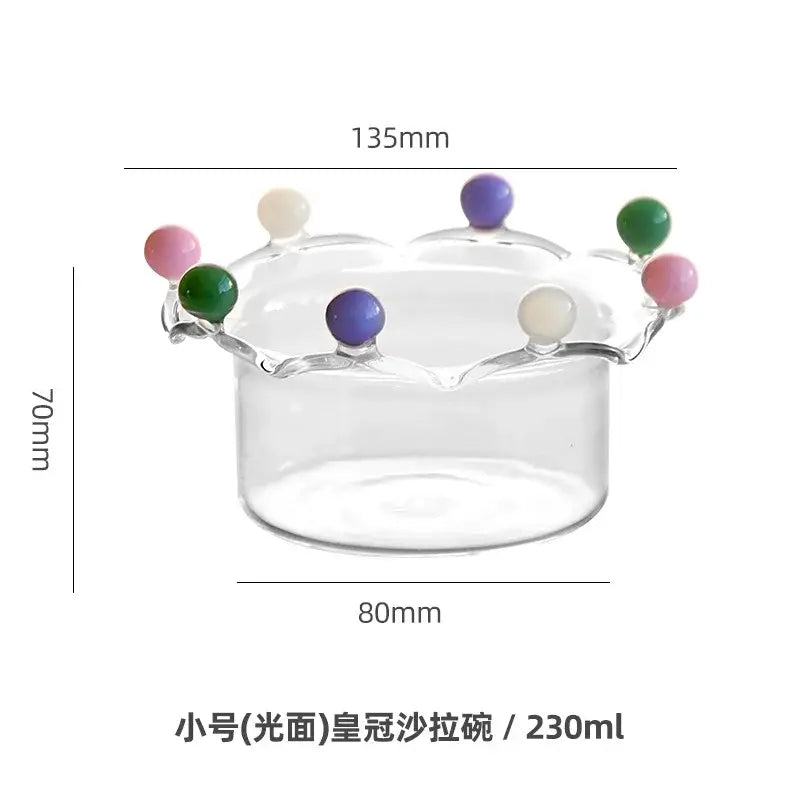 Clear glass fruit bowl with crown shaped rim adorned with colorful decorbites beads in pink green purple and cream