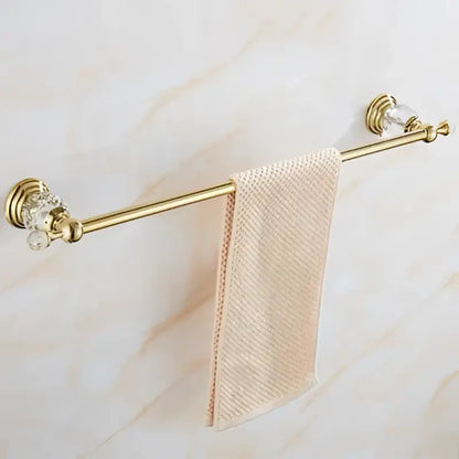 Gold-toned towel rack with crystal accents holding a light pink towel from crystal bathroom accessories set decorbites brass