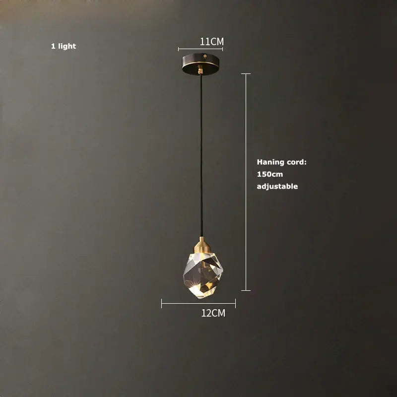 A modern crystal copper chandelier lighting with a faceted clear glass globe and brass accents for dining room decorbites