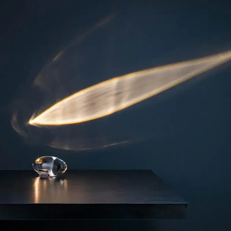 A sleek transparent crystal eye sky led table lamp with metallic accent on dark surface for bedroom decorbites table lamp