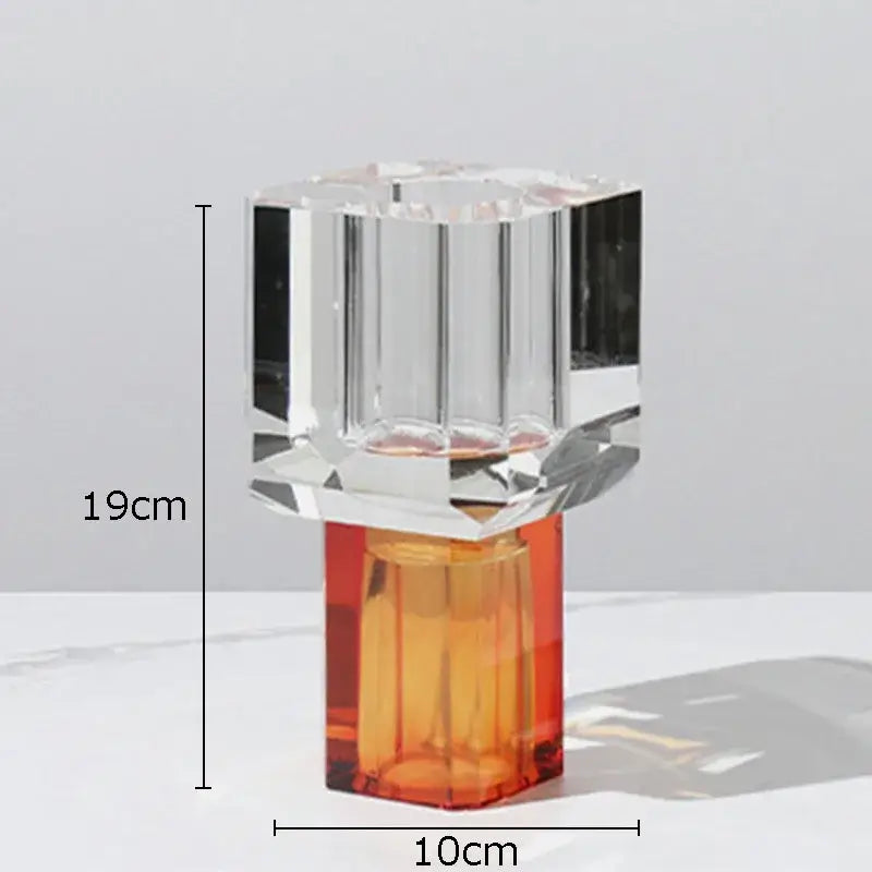 A crystal clear glass vase with a faceted design and vibrant orange translucent base for living room decor