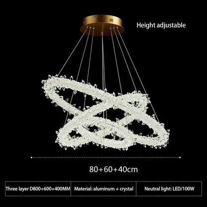 A modern height-adjustable crystal flower led ring chandelier with three interlocking rings and gold-toned aluminum base for dining room lighting