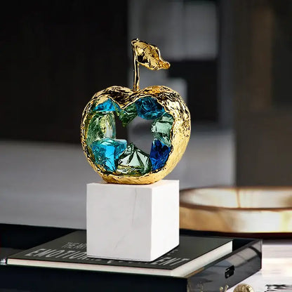 Golden apple decorbites crystal fruit sculpture with textured metal exterior and vibrant blue green glass interior for living room