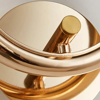 Gold-toned decorbites crystal nordic wall sconce with sleek curved polished metallic finish for bedroom lighting
