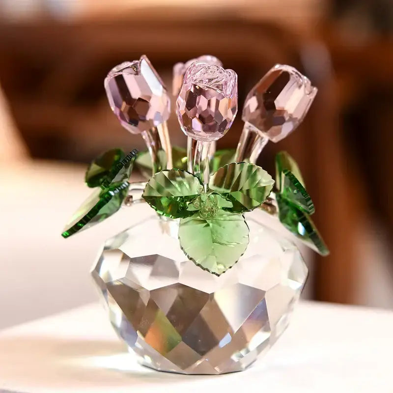 A delicate pink crystal rose flower dreams glass paperweight bouquet with green leaves in a faceted clear vase