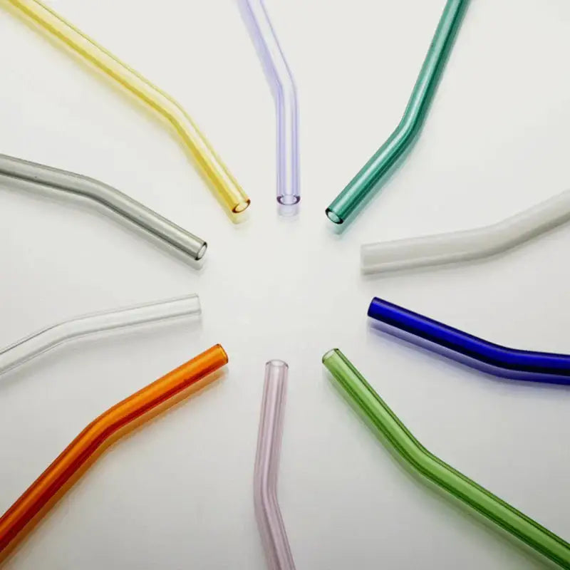 A collection of colorful curved glass drinking straws including amber hues for kitchen accessory use