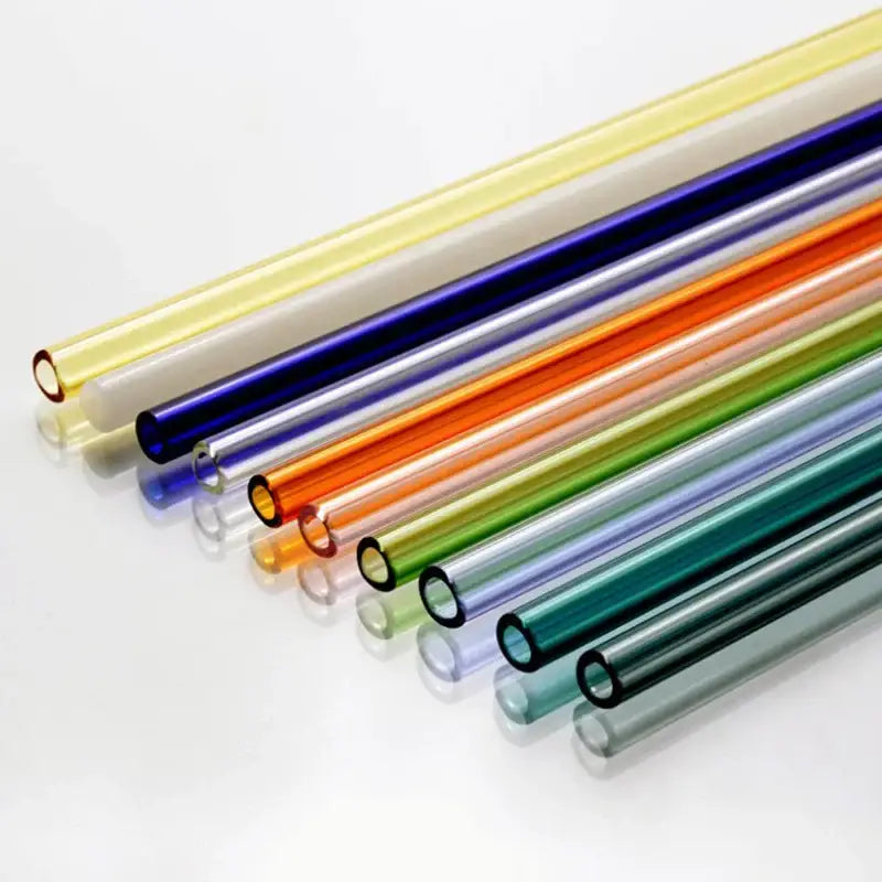 A collection of curved amber glass drinking straws in vibrant yellow blue orange green and purple for kitchen use