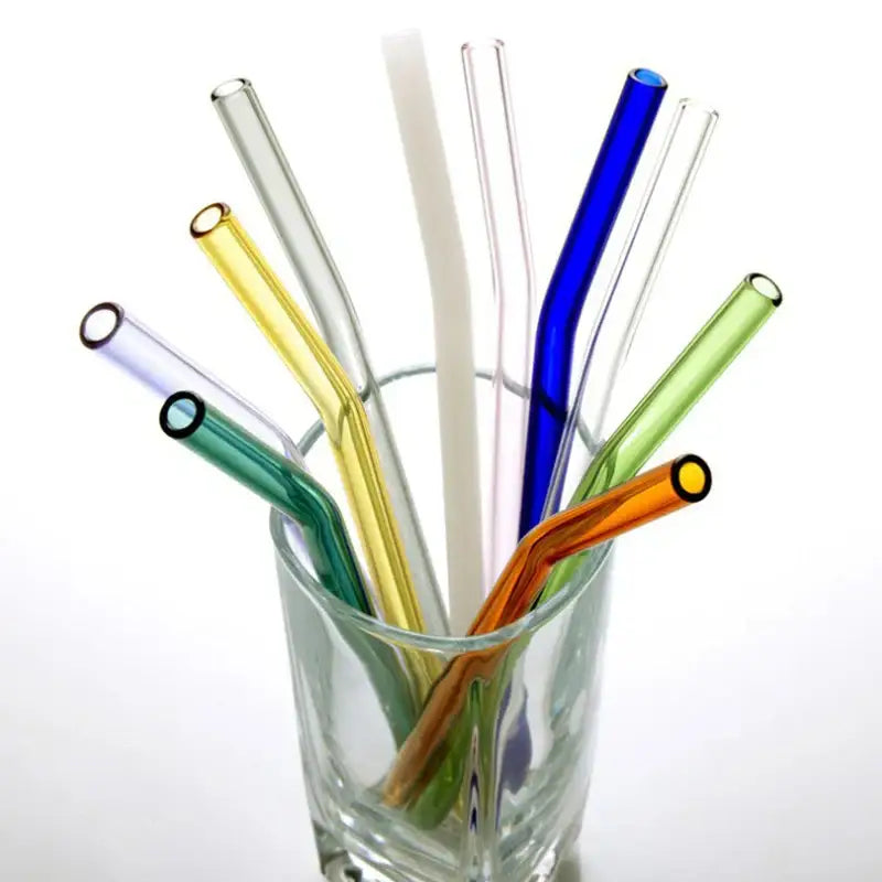 A collection of colorful curved glass drinking straws in blue green yellow orange clear for kitchen use