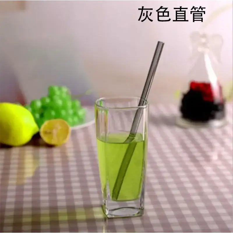 Gray stainless steel drinking straw shown alongside a curved amber glass drinking straw kitchen accessory