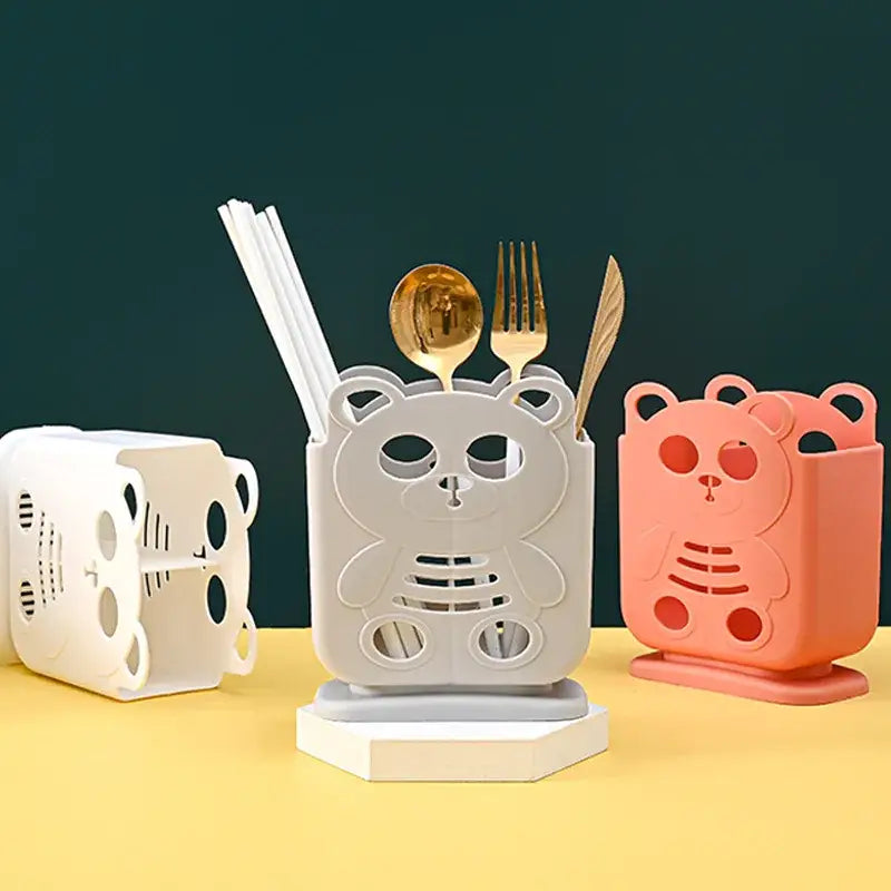 White plastic bear-shaped cutlery organizer stand with cut-out eyes and belly details for kitchen storage decorbites
