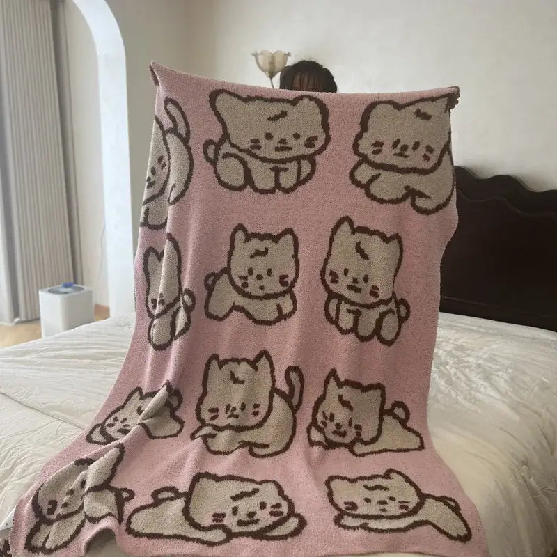 Pink knitted flannel blanket featuring a cute cartoon beige and brown cat pattern perfect as a bedroom throw