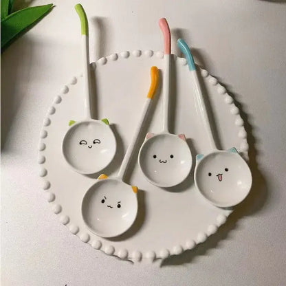 Set of four cute cat ceramic spoons with white cat faces and colorful green pink orange and blue handles for dessert serving