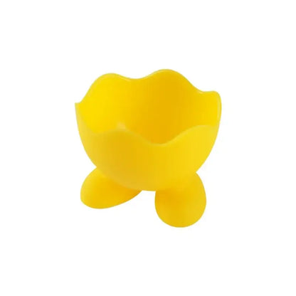 Bright yellow silicone egg cup holder with scalloped rim and three rounded feet for kitchen breakfast use