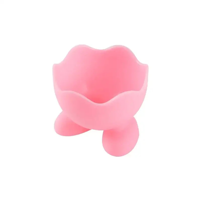 Pink silicone egg cup holder with flower-shaped rim and three rounded feet for kitchen breakfast use