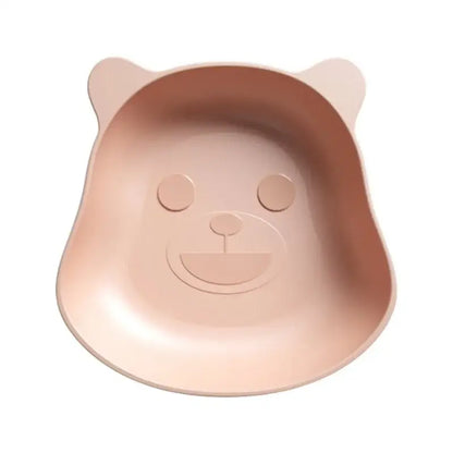 A soft pink bear shape plastic fruit plate with molded ears and smiling face for kitchen snacks