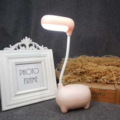 A soft pink decorbites elk night lamp shaped like a pig with a flexible neck and illuminated led head for desk decor