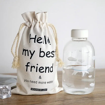 Cream-colored cotton drawstring bag with black text designed by lokki for decorbites blue glass water bottle decor