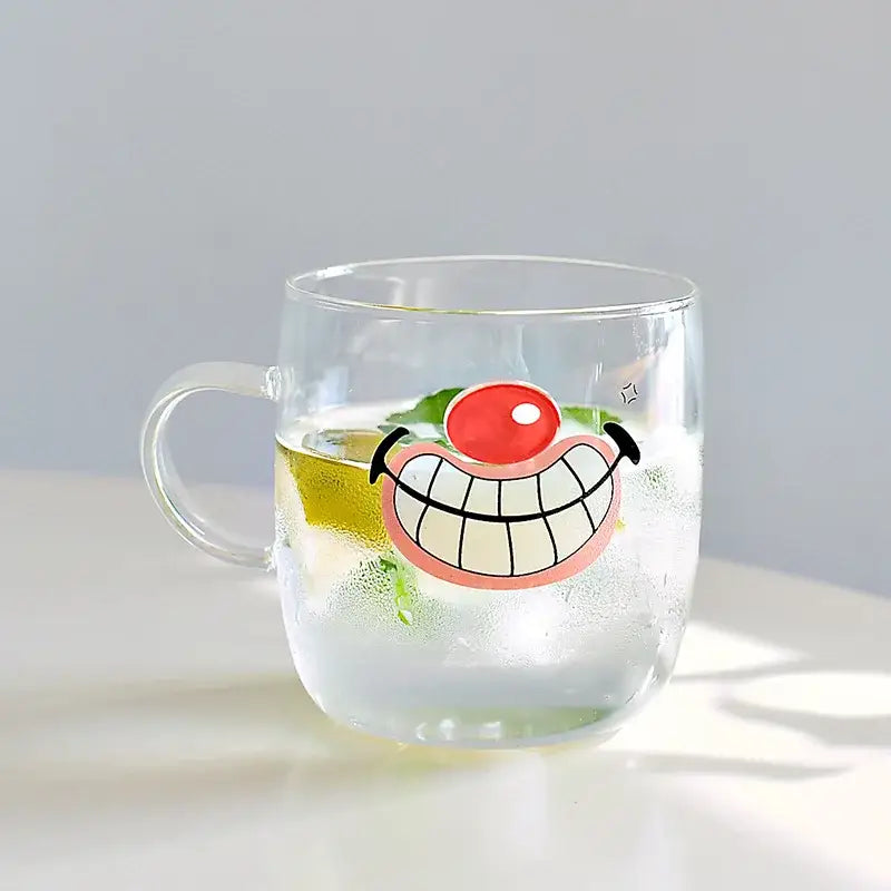 Clear glass coffee mug with cartoon smiling face red nose and pink lips filled with ice water and lime slices