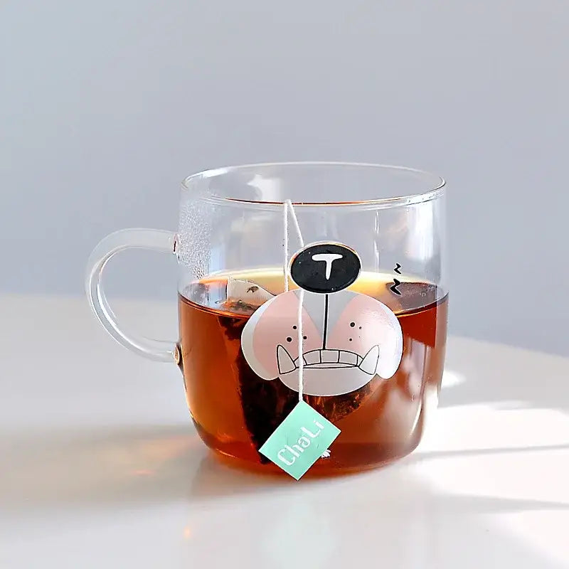 Clear glass coffee mug featuring a cute pink and white cartoon polar bear design with a black t above its head