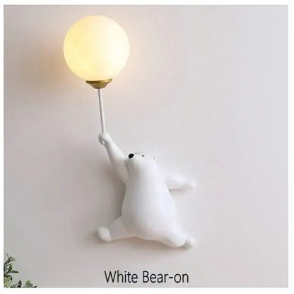 White matte finish bear wall lamp holding a glowing spherical bulb on a slender stem for bedroom lighting